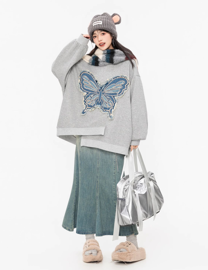 Detailed product view of an oversized grey butterfly hoodie with textured blue denim appliqué and contemporary Korean streetwear styling