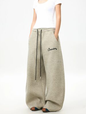Front view of relaxed striped fleece wide-leg pants with elastic drawstring waistband, horizontal knit texture, and embroidered detail