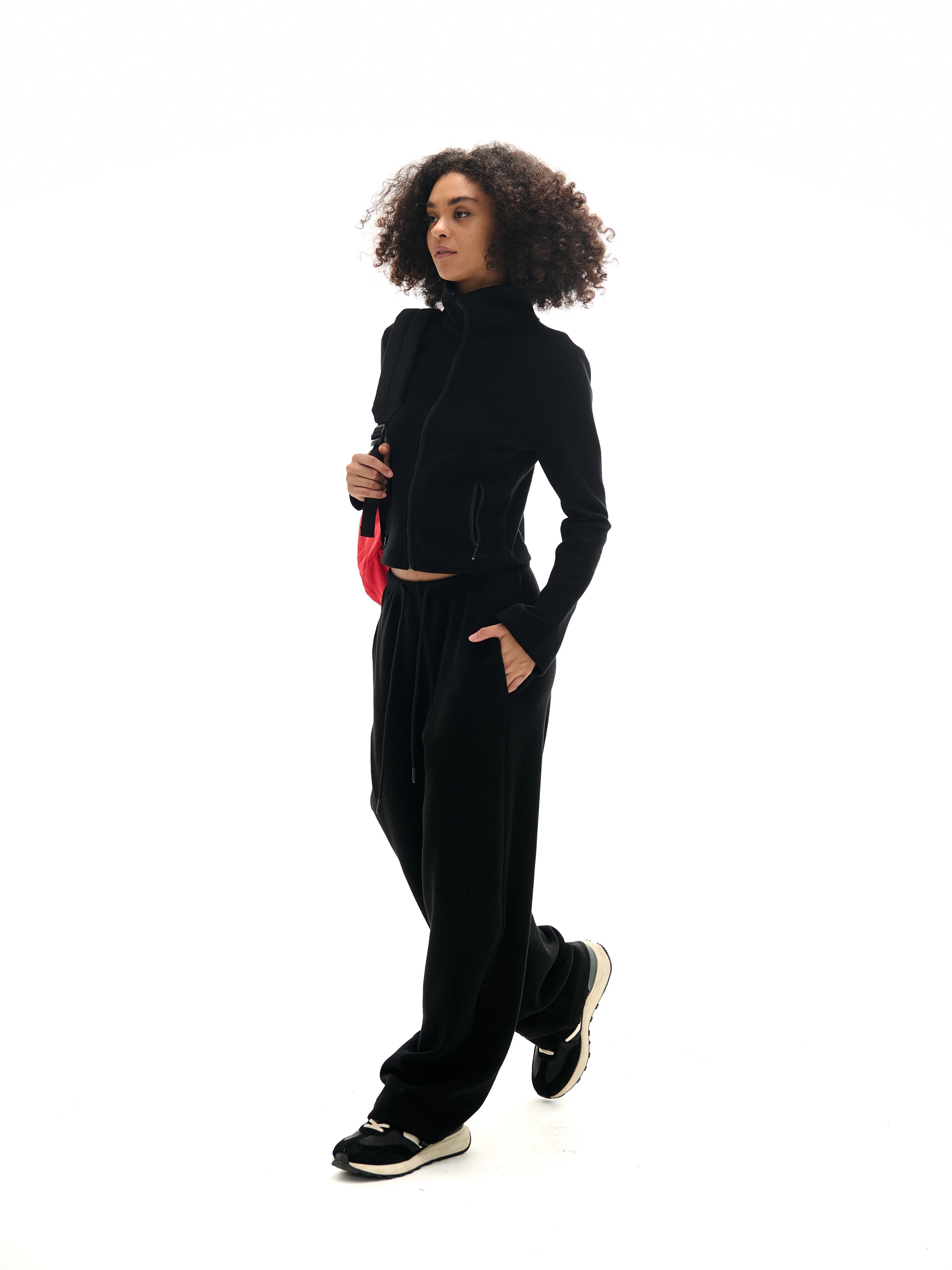 Black cropped high collar zip-up sweatshirt and drawstring wide-leg sweatpants set with red crossbody bag