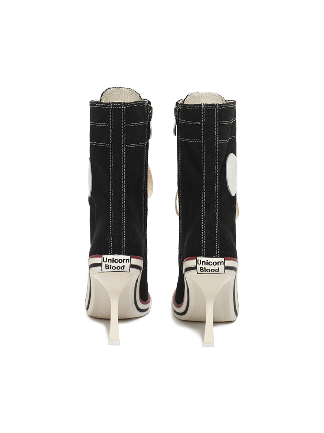 Rear back view of pair canvas stiletto boots on white background showing heel construction with visible branding text on sole red sole trim and back ankle patch design element