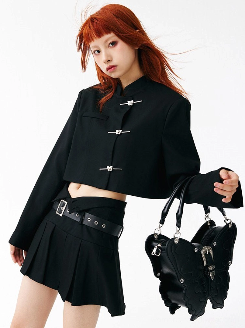 Black punk butterfly handbag held with one hand in a Korean streetwear inspired outfit
