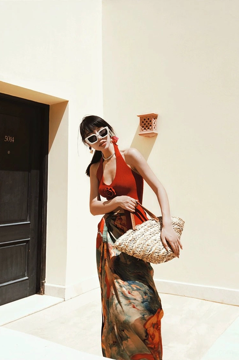 Abstract watercolor maxi skirt with adjustable tie waist styled with a red halter top and large woven straw tote bag
