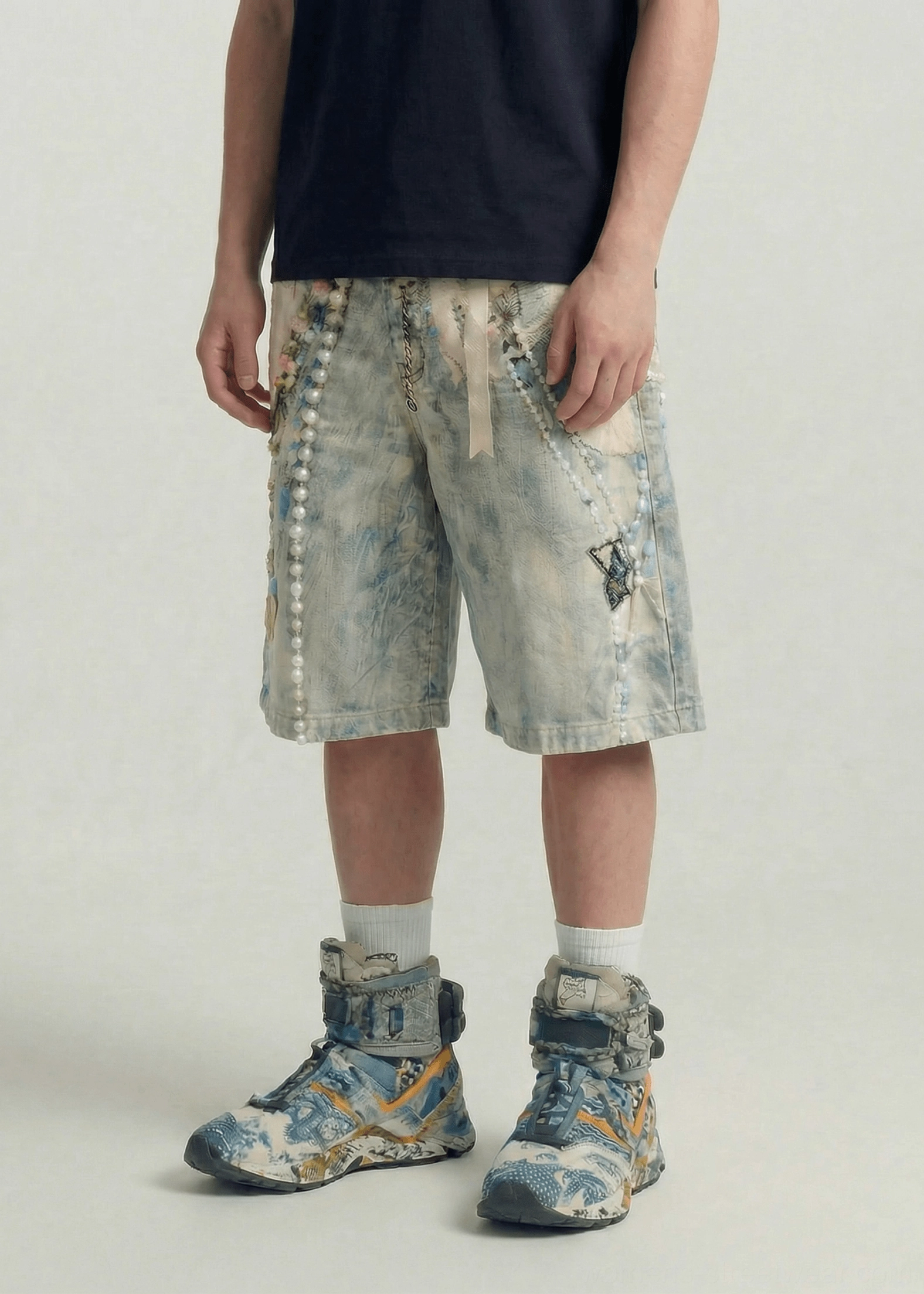 Three-quarter side view of loose fit acid wash denim jorts with pearl chain star embroidery and waist tie