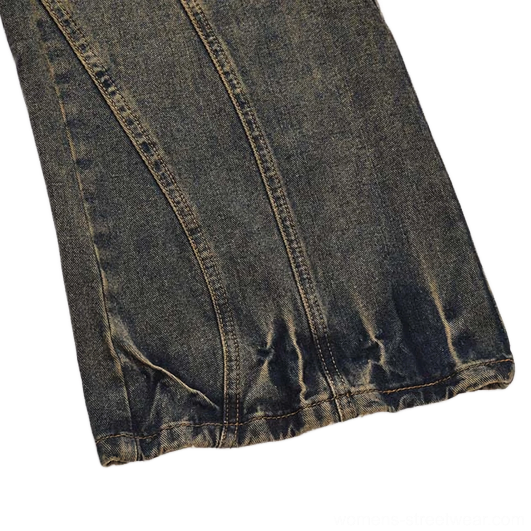 Side close-up of acid wash denim jeans leg featuring vertical curved panel seams, crushed trouser hem, and authentic vintage washed denim texture