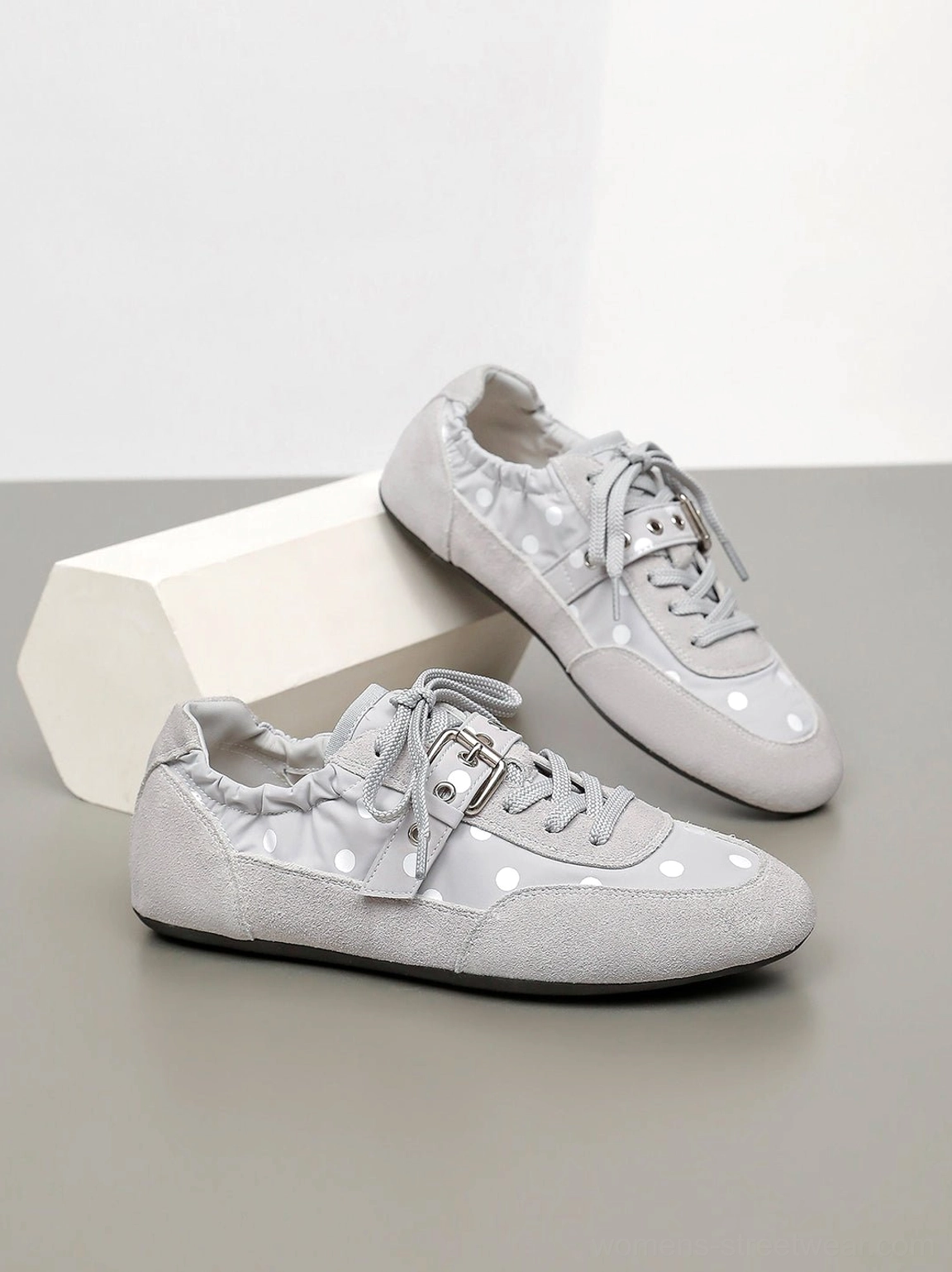 Acubi-inspired low-profile polka dot ballet sneakers with contrasting dots, buckle strap, and flat everyday sole