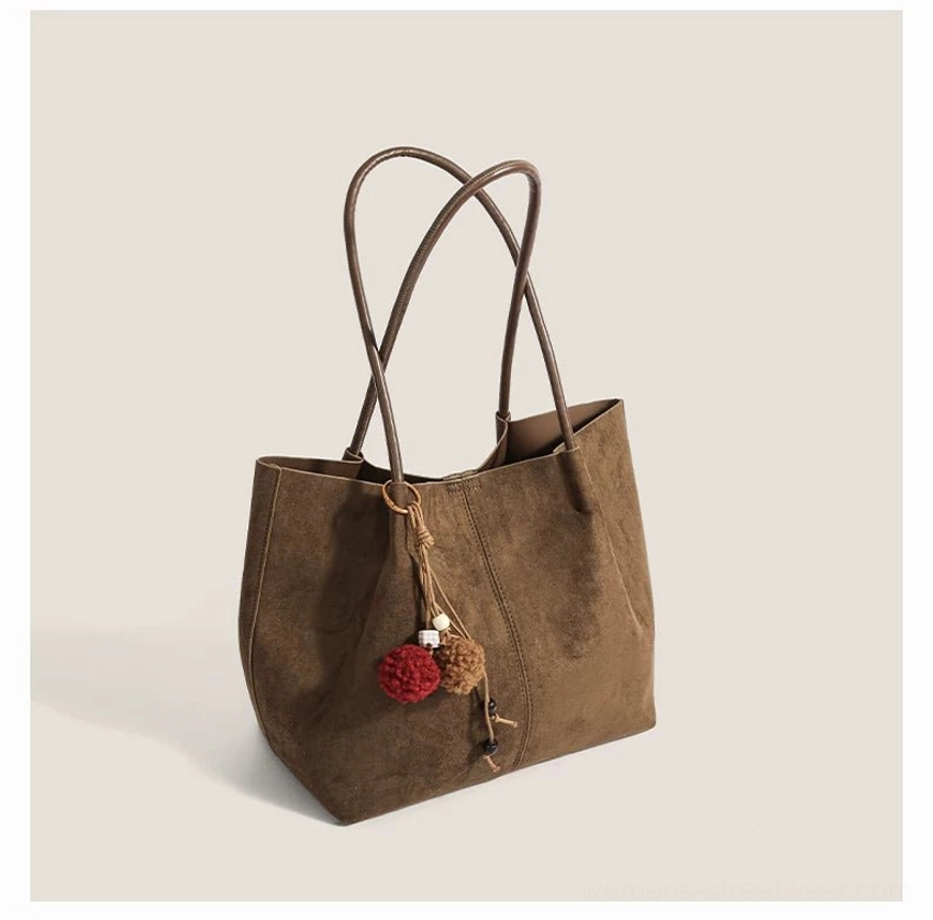 Acubi suede pom charm tote bag with minimalist vertical seam design and long shoulder straps for Korean streetwear styling