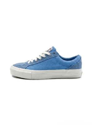 Sky blue Afro-embroidered casual skate sneakers shown from the left side with white flat laces, padded low-top shape, layered fabric panels, and substantial white rubber soles