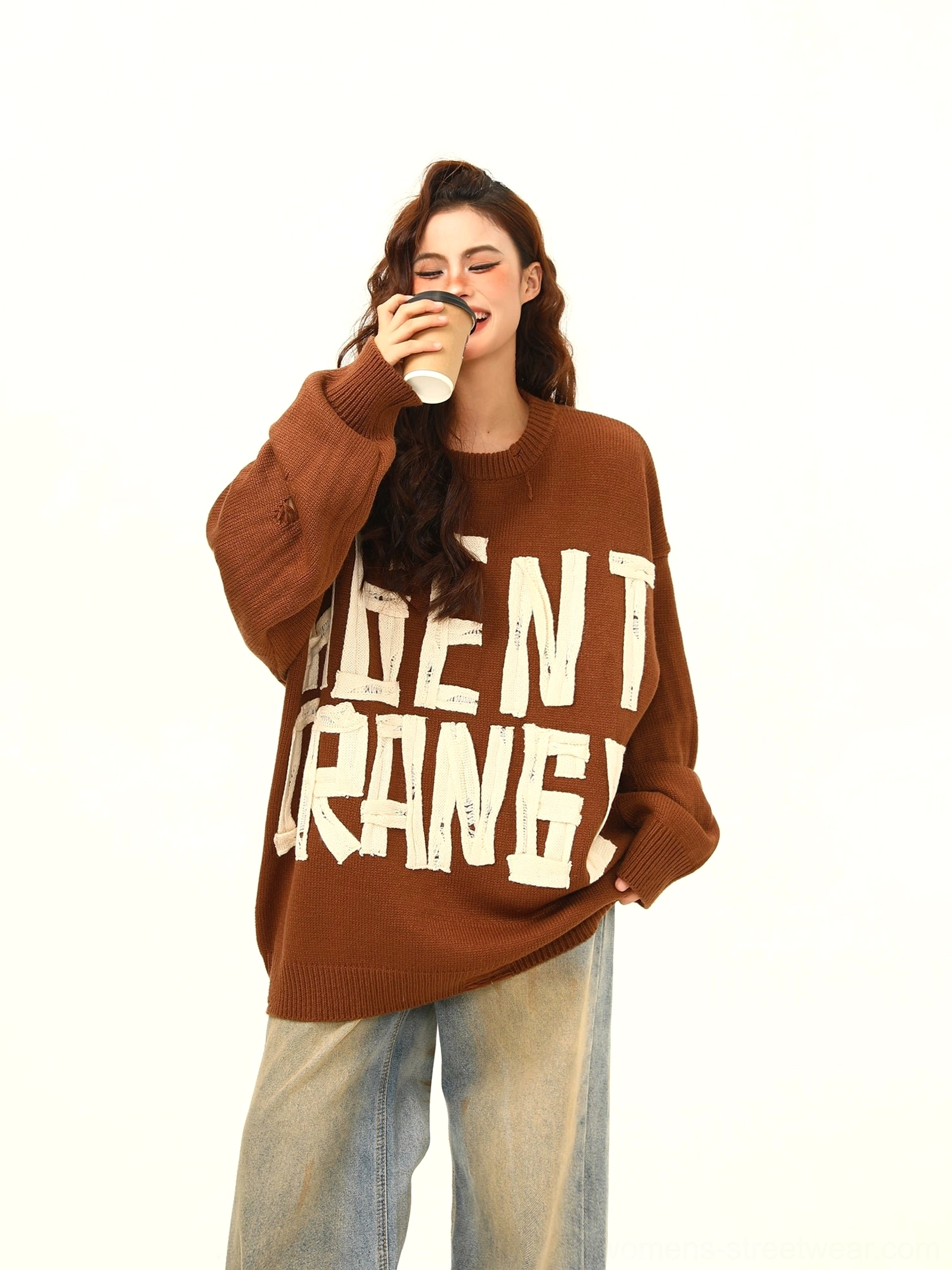 Brown Agent Orange distressed oversized graphic knit sweater front view styled with vintage wide leg jeans