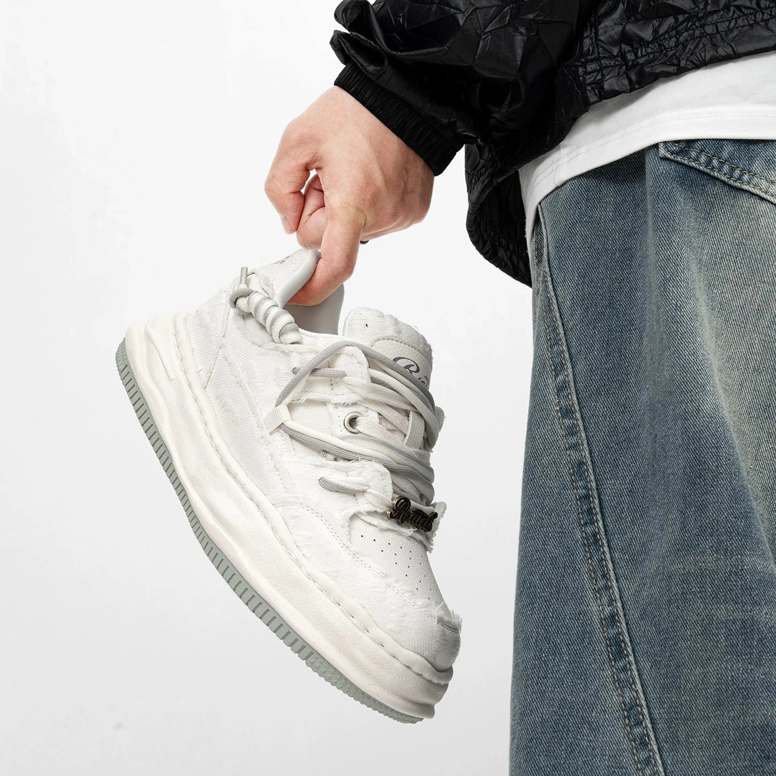All white distressed thick sole sneakers with worn textile texture and off white platform midsole shown in a low side profile