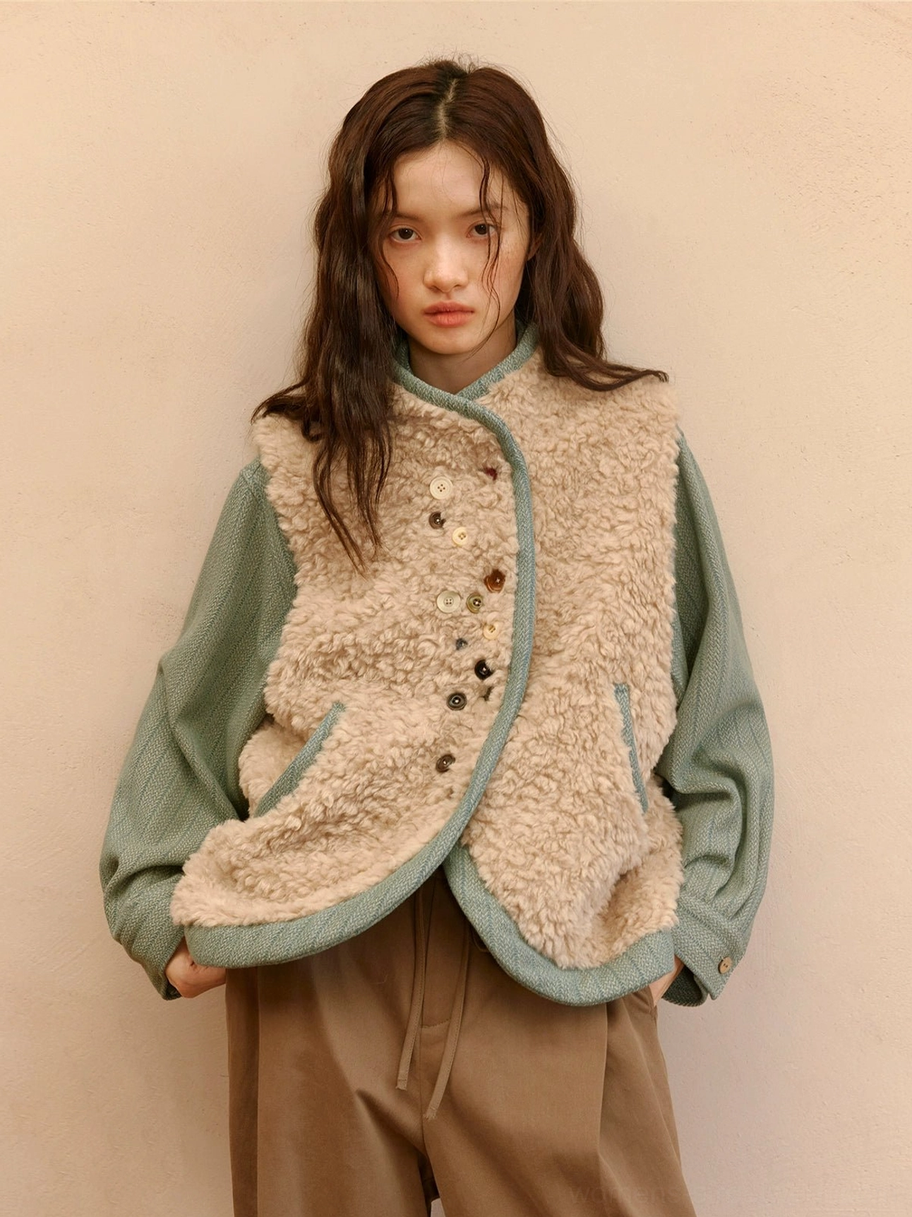 Almond beige reversible sherpa vest with sage green contrast trim and artistic multicolor button closure