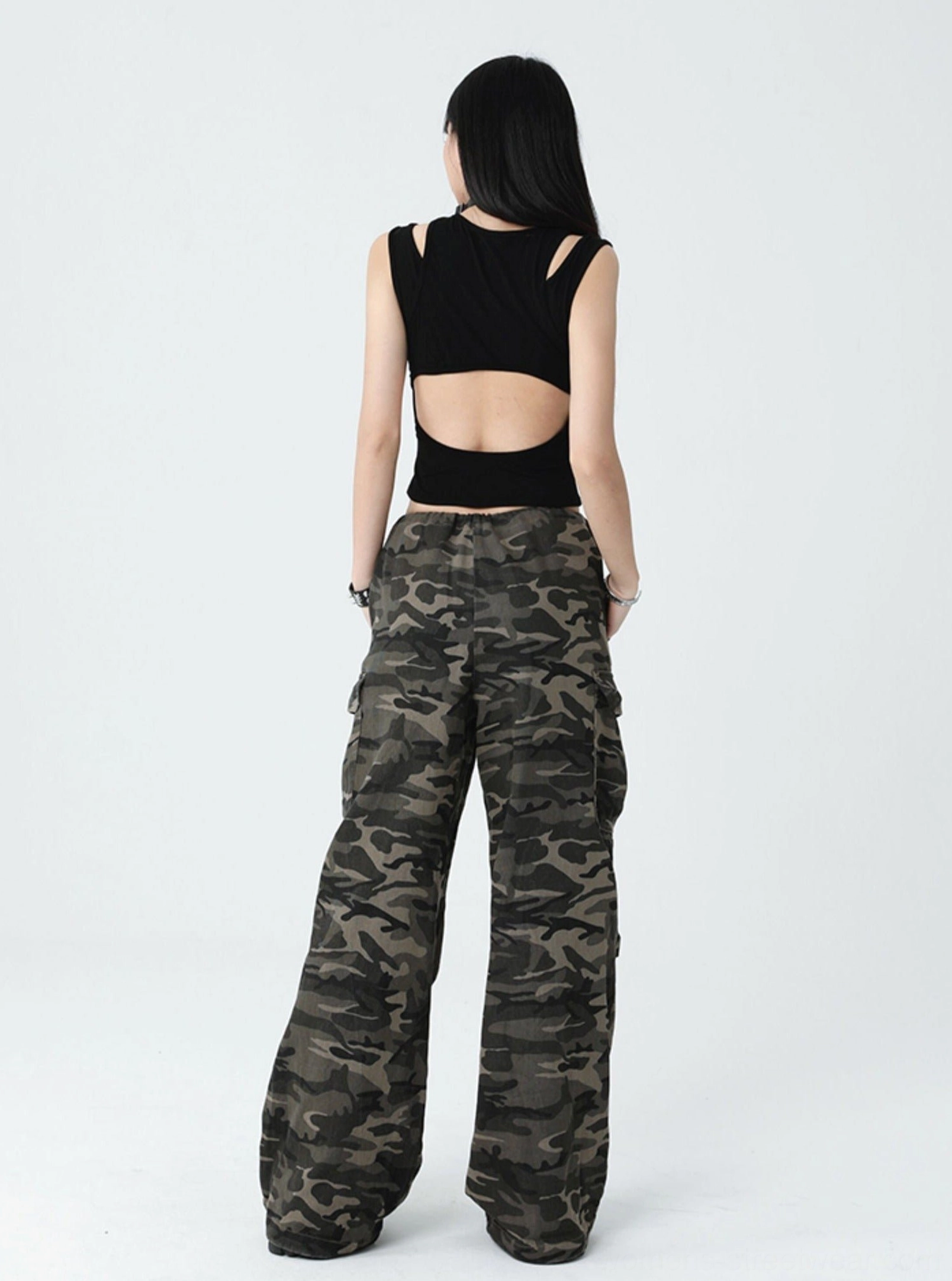 Alternative women's black cropped tank top featuring a cross graphic, ribbed texture, shoulder cutouts, and contemporary gothic fashion styling