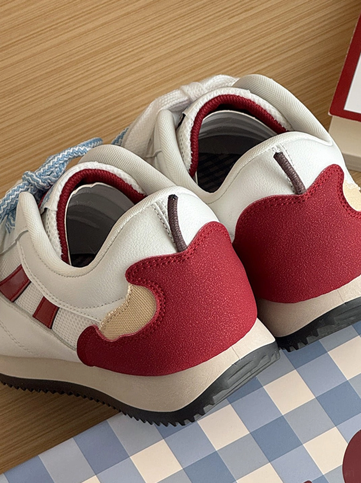 Side and rear close-up of apple detail red mesh retro runner sneakers with wine red stripes and retro runner sole