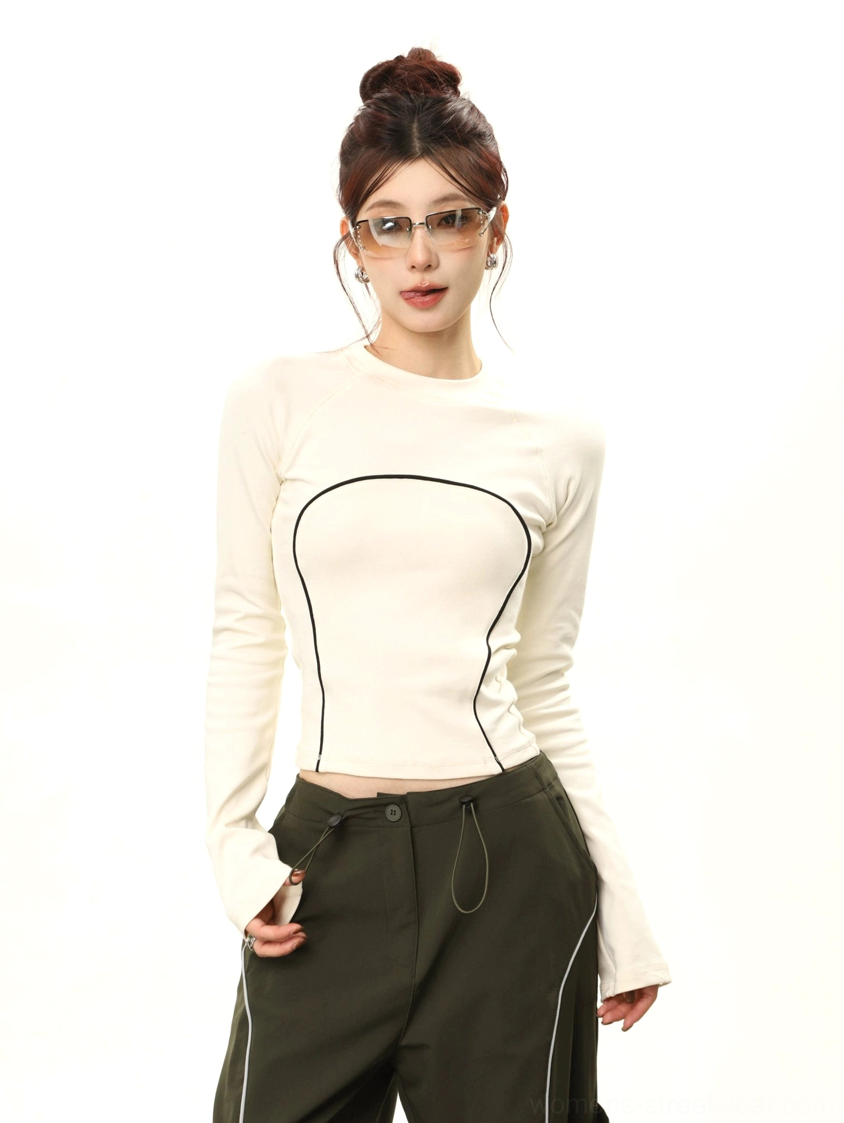 Apricot cropped fitted long sleeve top with black curved contrast stitching close-up streetwear outfit view