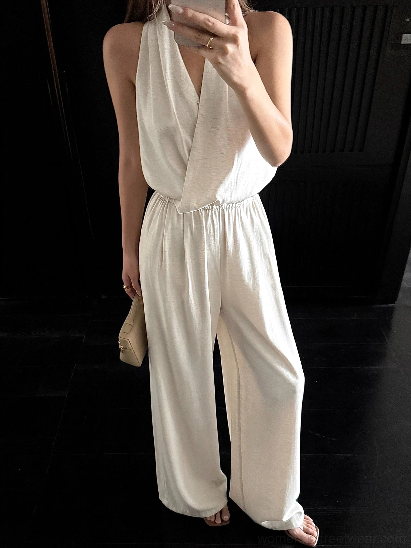 Apricot draped halter wide-leg jumpsuit mirror selfie with wrap V-neck, elastic waist, and linen-textured fabric
