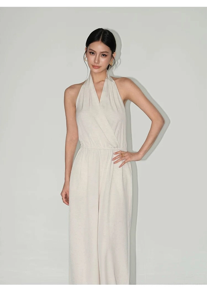Apricot draped halter wide-leg jumpsuit side view with wrap neckline, elastic waist, and fluid linen-style texture