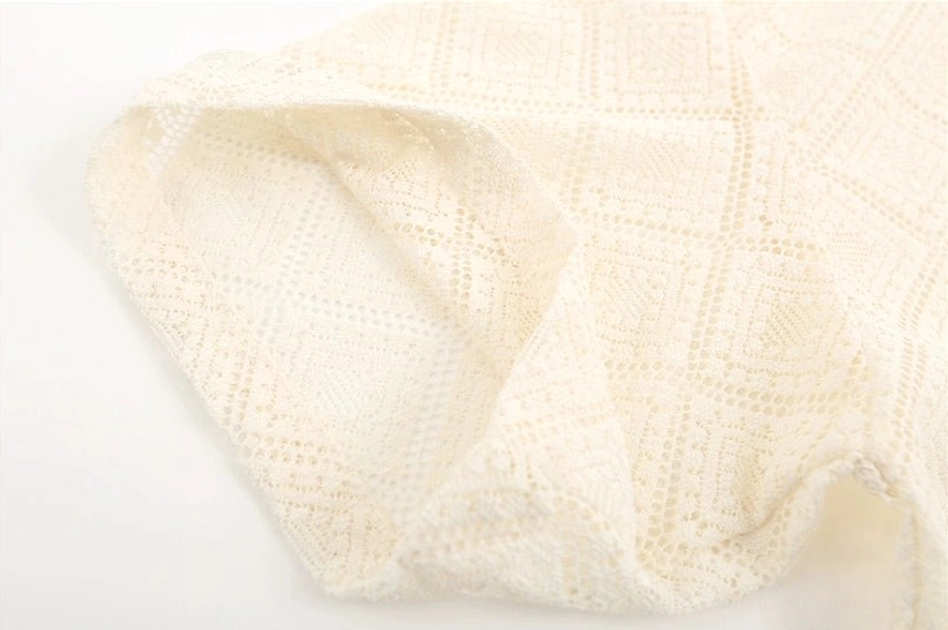 Apricot off-white geometric hollow lace fabric close-up for sheer oversized short sleeve shirt
