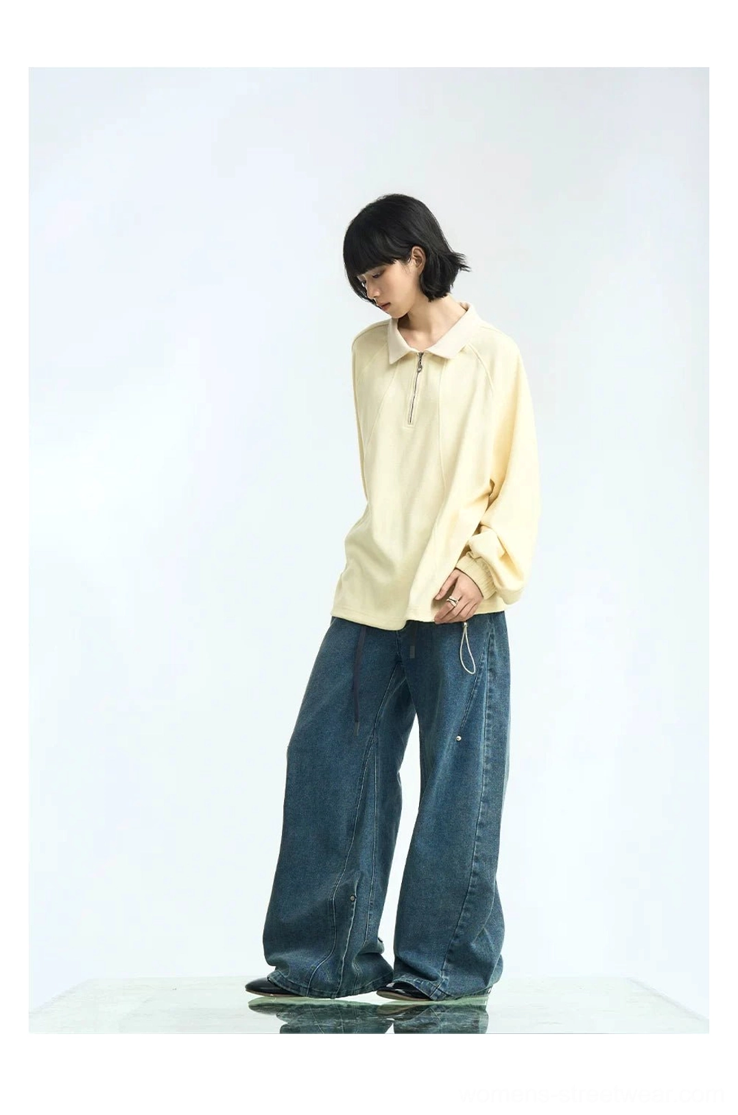 Apricot cream half-zip raglan polo pullover with quarter-zip neckline styled with wide-leg blue denim jeans