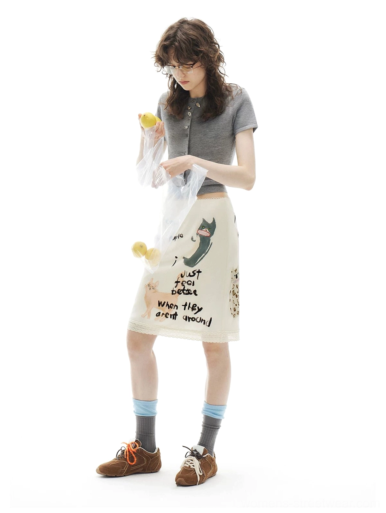 Apricot cream kitty print pencil skirt worn with a cropped grey top and sneakers in a relaxed daily streetwear look