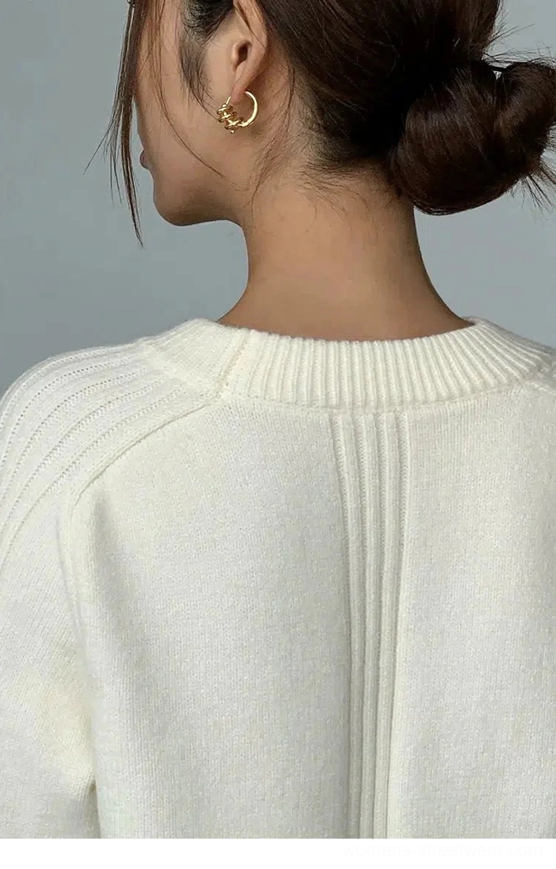 Back view of Apricot loose crew neck sweater showing ribbed neckline and vertical shoulder seam knit detail