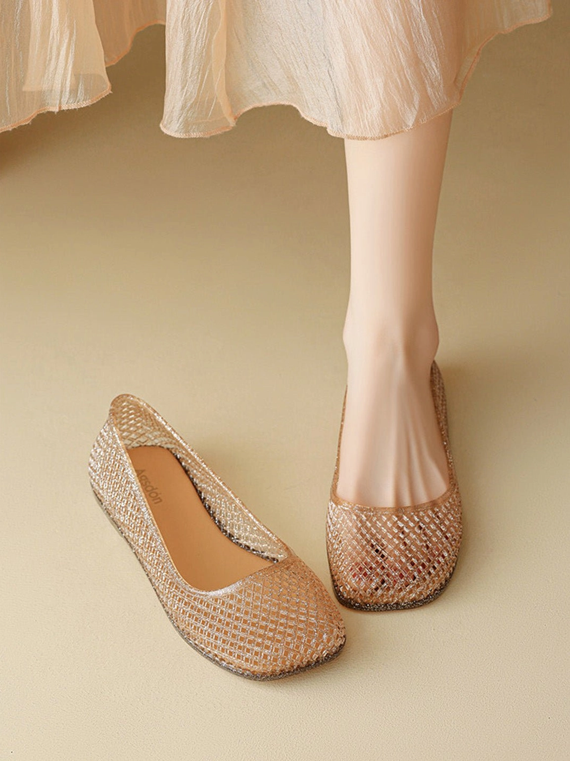 Model wearing light brown apricot mesh jelly ballet flats with a beige midi skirt