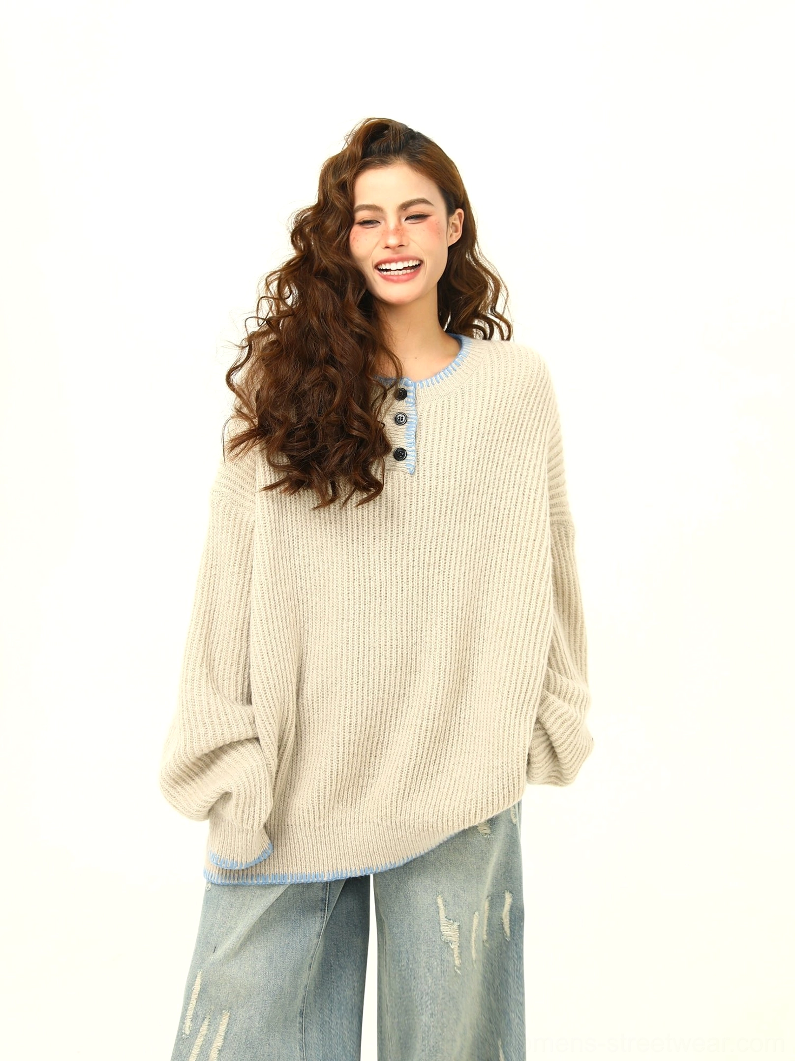 Apricot oversized ribbed knit sweater showing half-button placket, light blue trim, and relaxed drop-shoulder fit