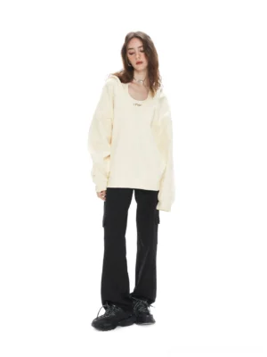 Apricot oversized V-neck hoodie sweatshirt styled with black cargo pants and chunky sneakers in a relaxed Seoul streetwear outfit