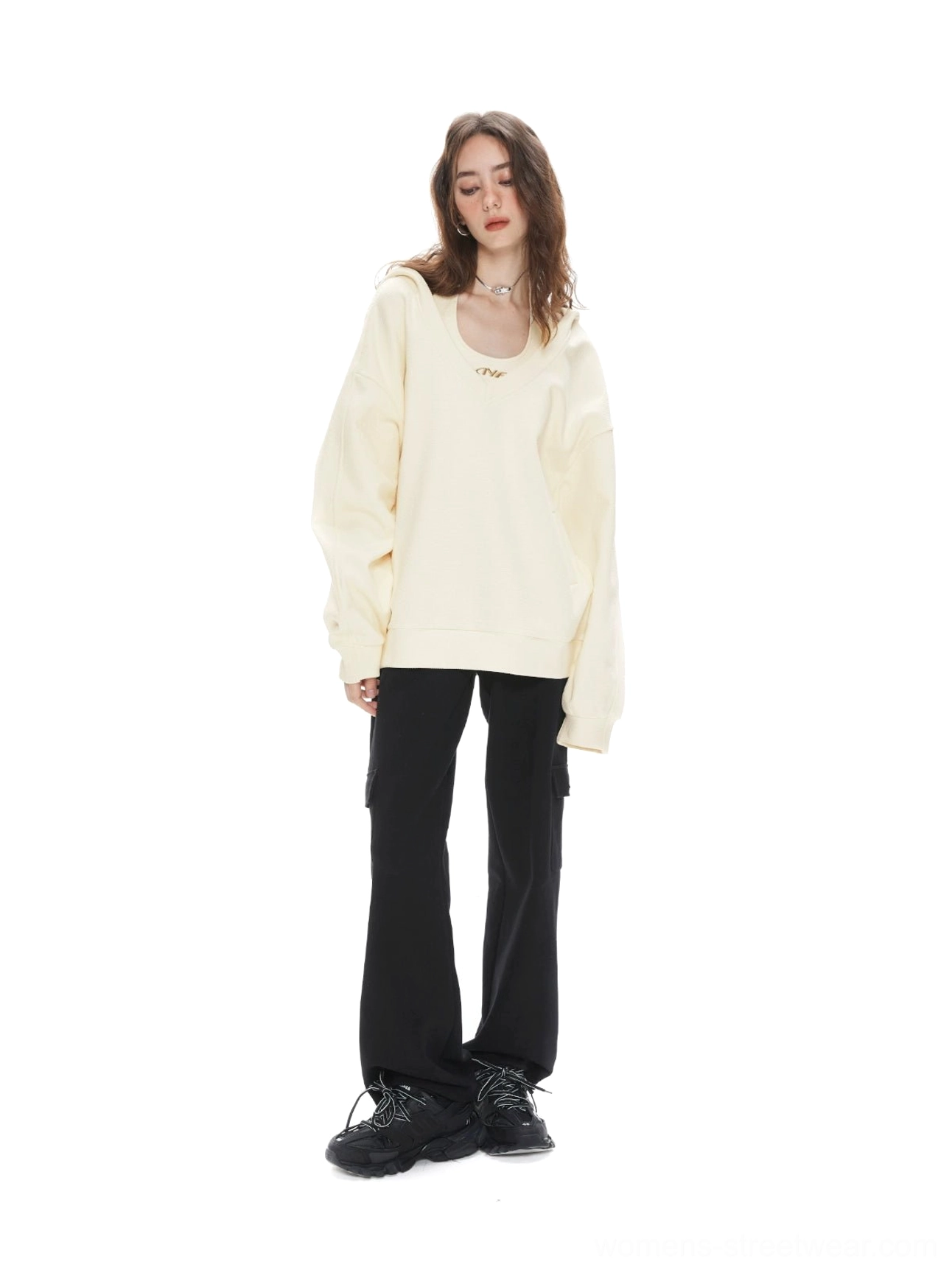 Apricot oversized V-neck hoodie sweatshirt styled with black cargo pants and chunky sneakers in a relaxed Seoul streetwear outfit