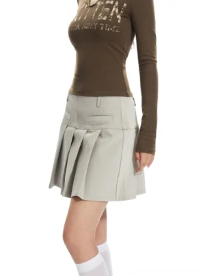 Apricot pleated mini skirt shown from the left side with crisp uniform pleats, structured waistband, and clean preppy Korean streetwear styling
