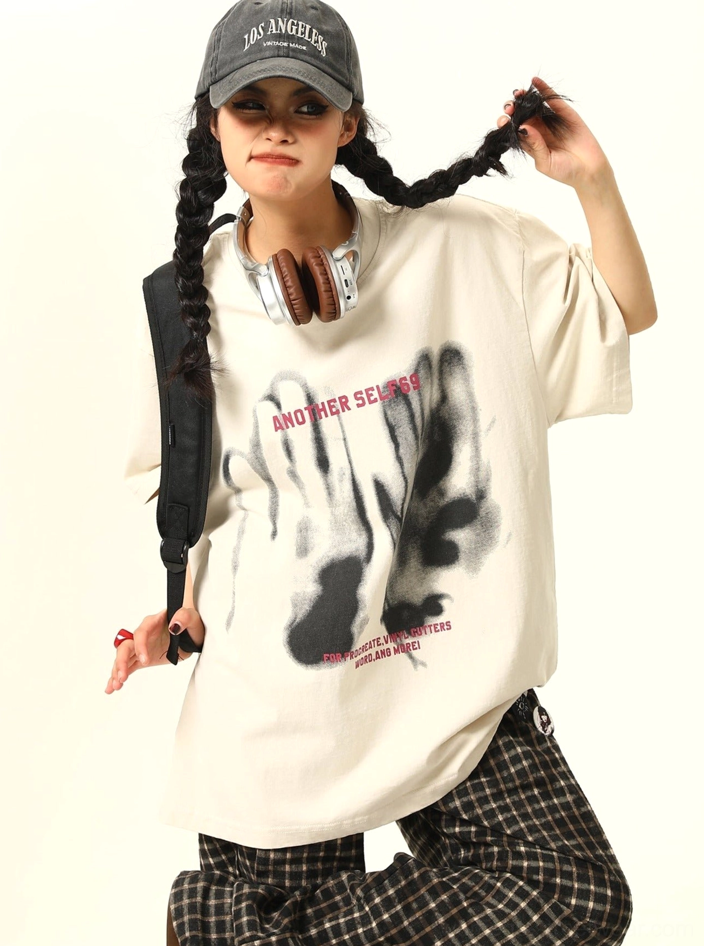 Apricot oversized selfie graphic tee with dropped shoulders black hand print and pink lettering shown in a playful Korean streetwear outfit