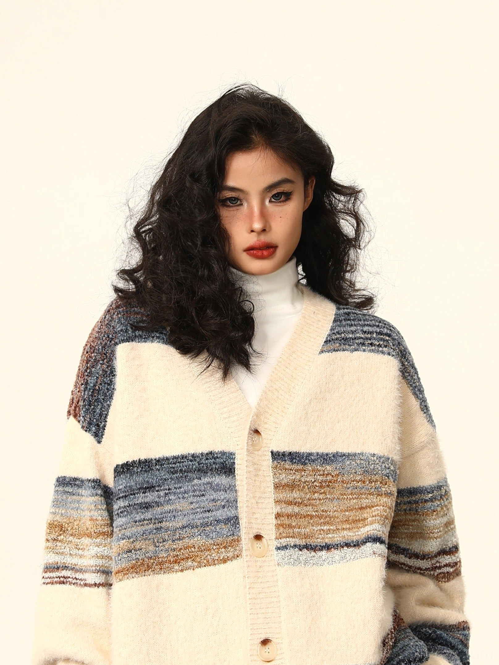 Close-up of apricot striped mohair cardigan showing soft fuzzy texture V-neckline colorful horizontal stripes and button placket