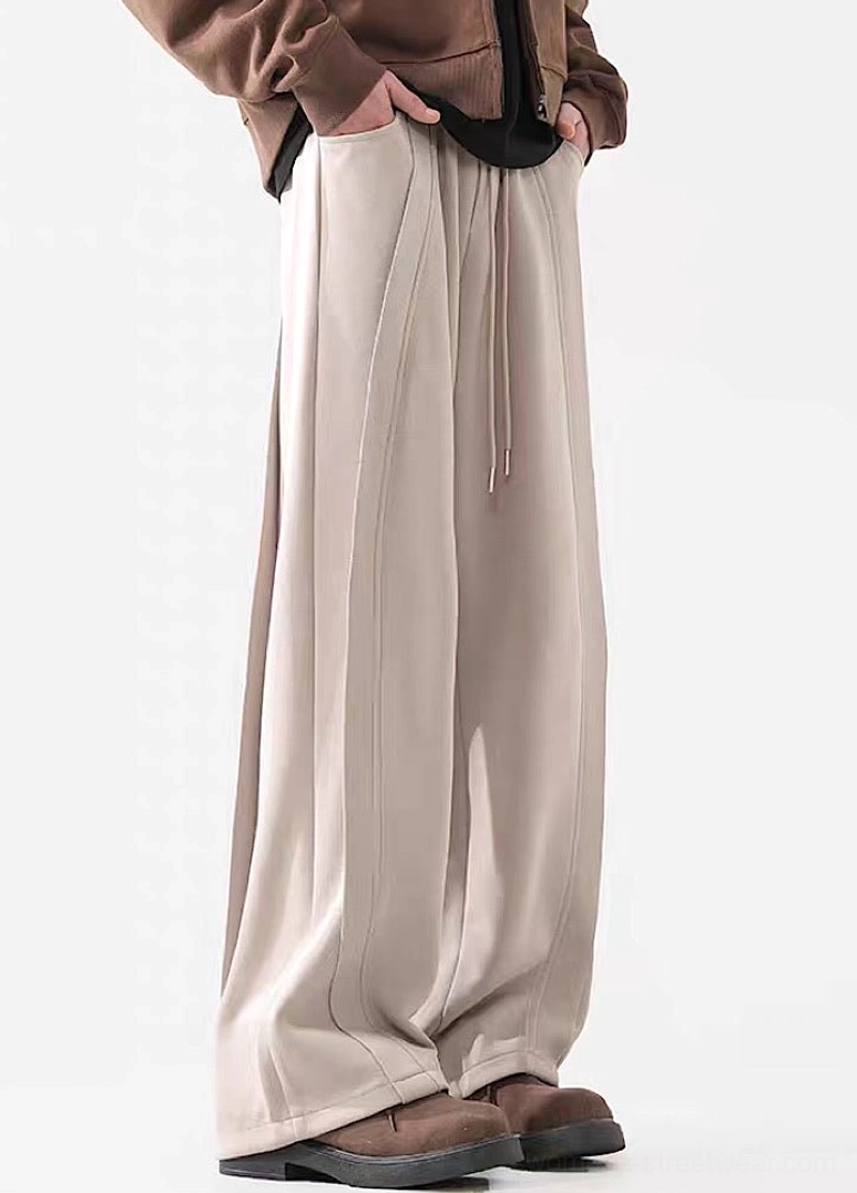 Side view of taupe Apricot washed wide-leg pants with relaxed fit and brown leather work shoes