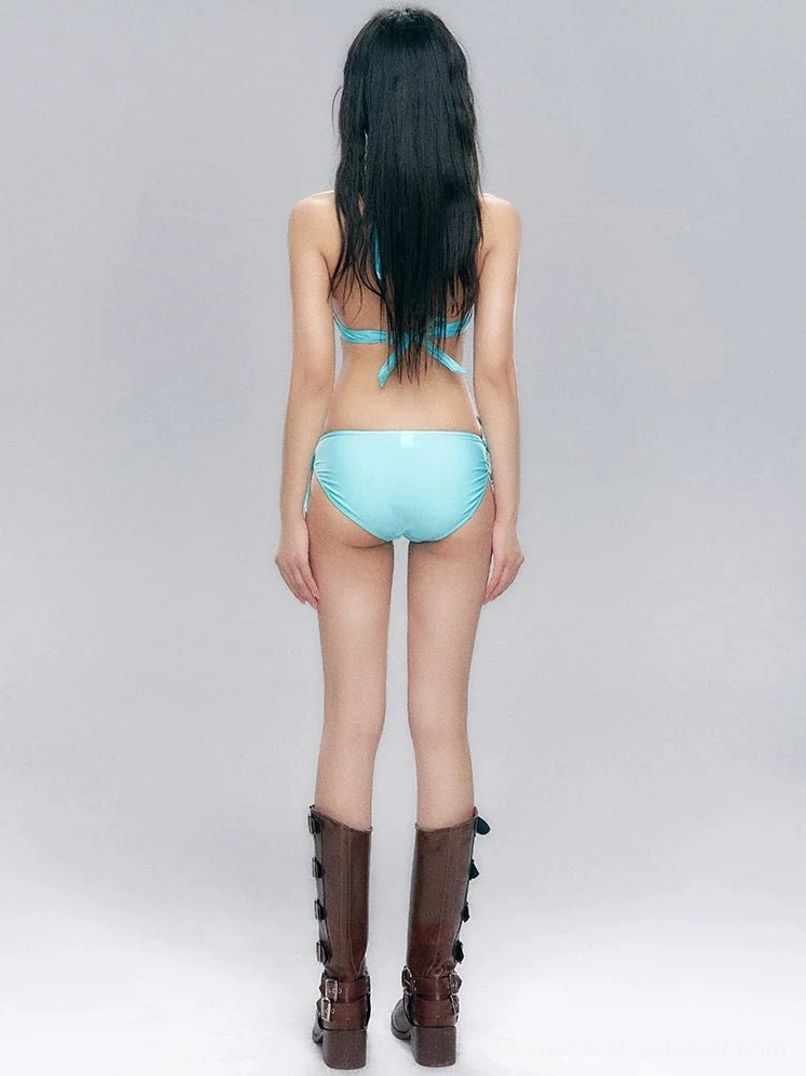 Back view of an aqua blue tie-back halter bikini top with adjustable tie-side bottoms and brown multi-buckle boots