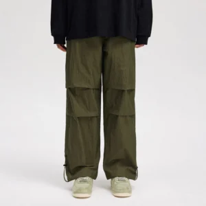 Army green wide-leg streetwear track pants back view with articulated knee panels and adjustable ankle drawstrings