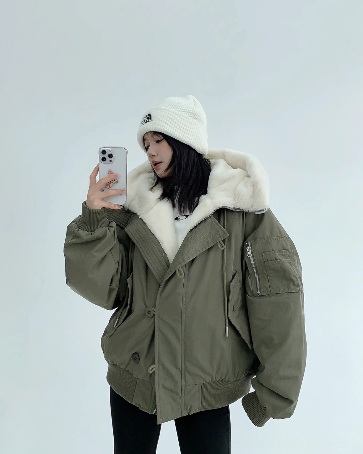 Army green oversized bomber jacket with faux-shearling hood, sleeve utility pocket, drawcord hood, and ribbed cuffs