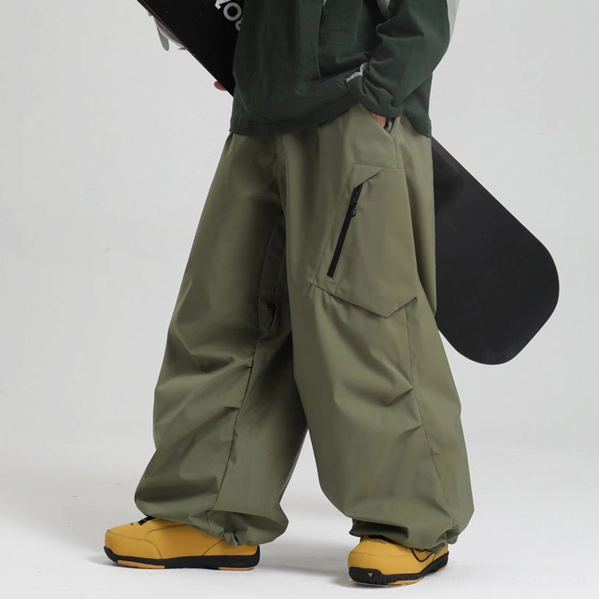 Army green wide-leg cargo snow pants male model dark top yellow boots crinkled seam detail baggy fit
