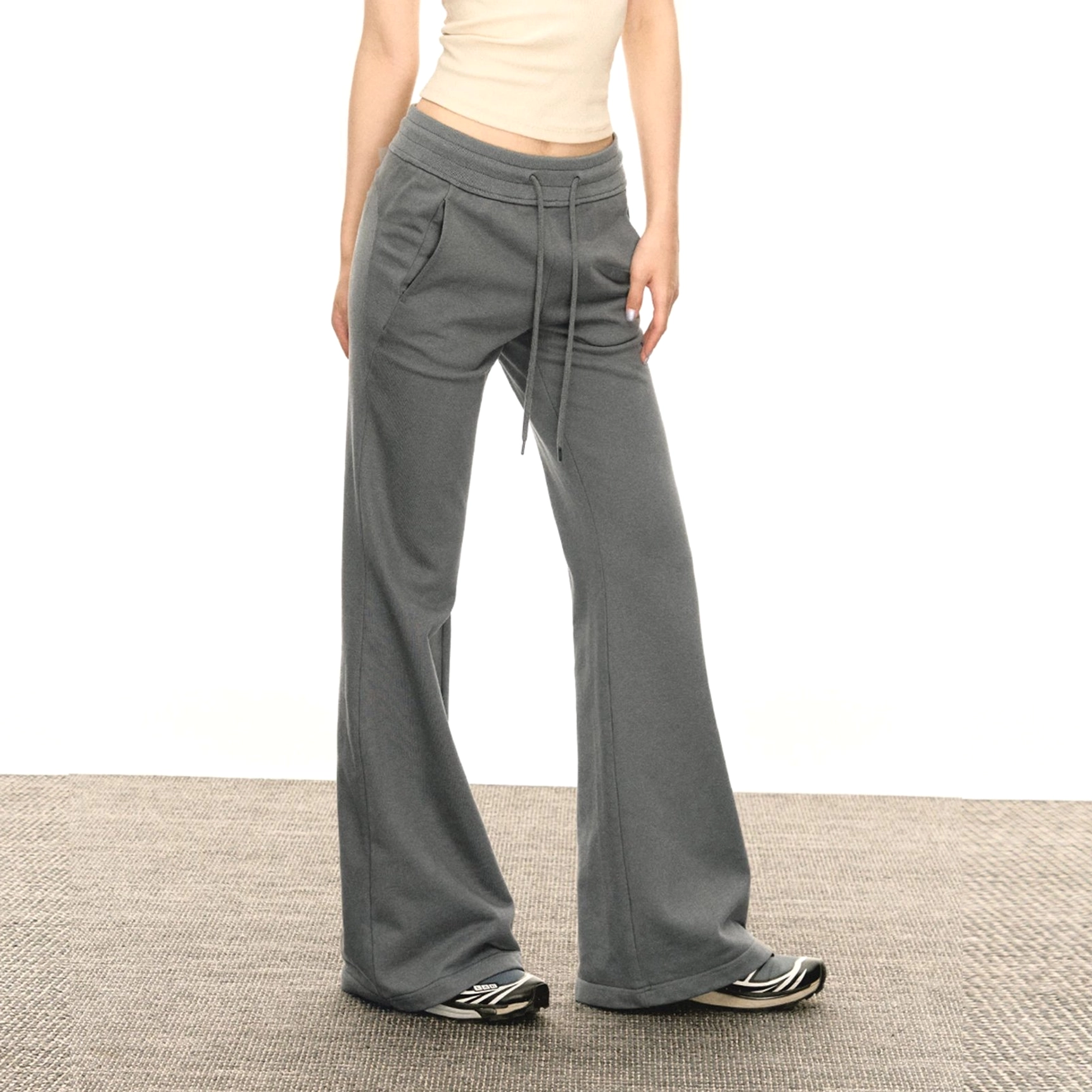 Front full-body view of light gray ash flared sweatpants with a high drawstring waist, slim fit, soft knit texture, and wide-leg silhouette