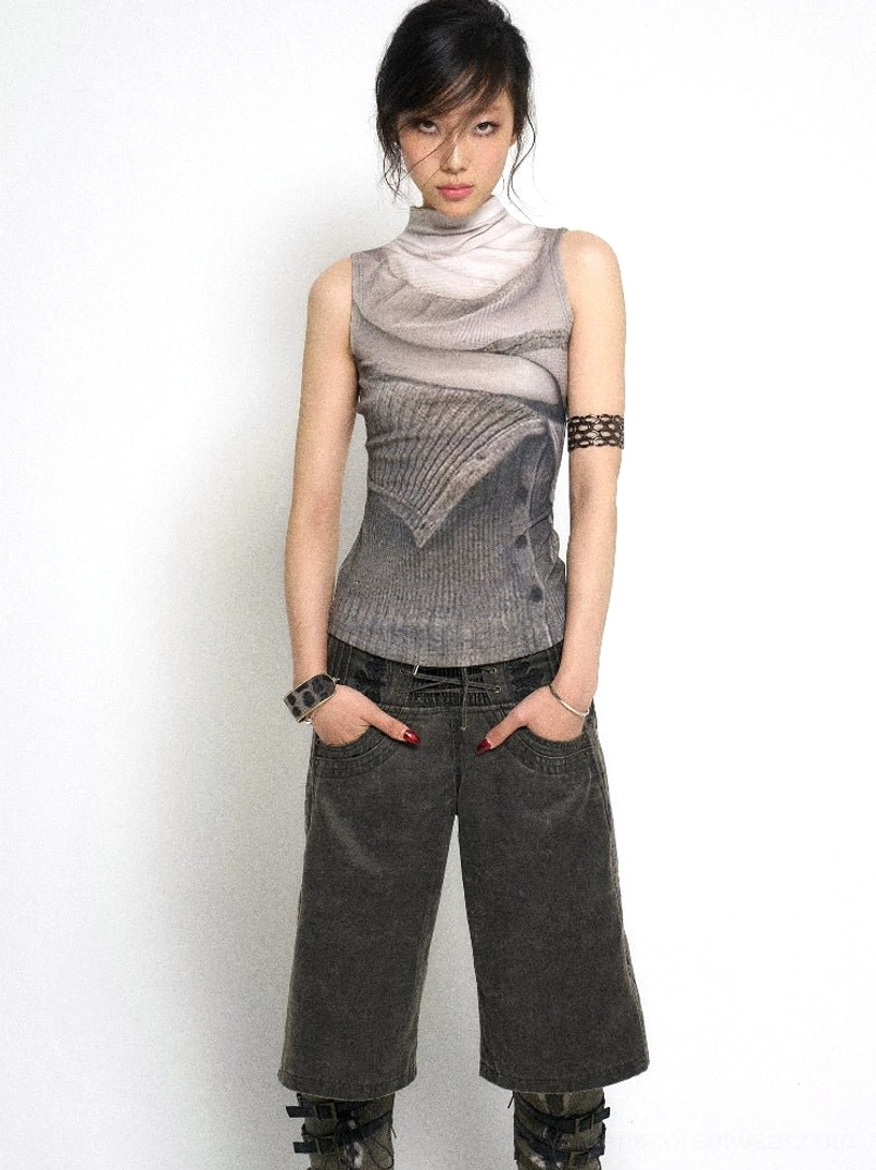 Front view of ash gray gradient layered knit mock neck tank top styled with dark wide leg pants and boots in a minimalist studio