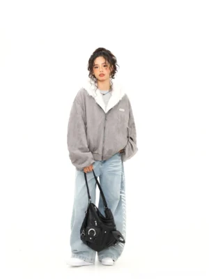 Full front view of ash gray faux suede reversible bomber jacket styled with wide-leg jeans and white sneakers