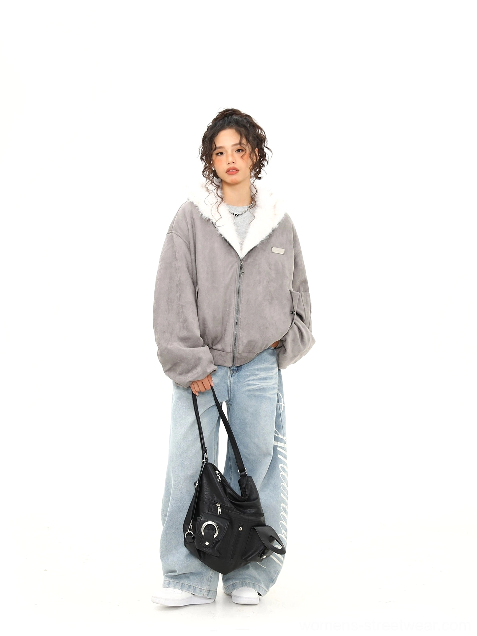 Full front view of ash gray faux suede reversible bomber jacket styled with wide-leg jeans and white sneakers