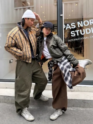 Two streetwear models wearing ash grey distressed leather cross lace-up high-top boots outdoors