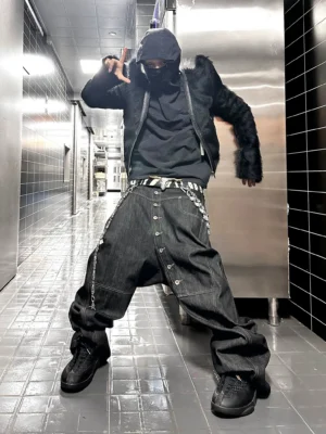 Black asymmetric button wide-leg denim streetwear jeans worn in an industrial hallway with oversized loose-leg silhouette