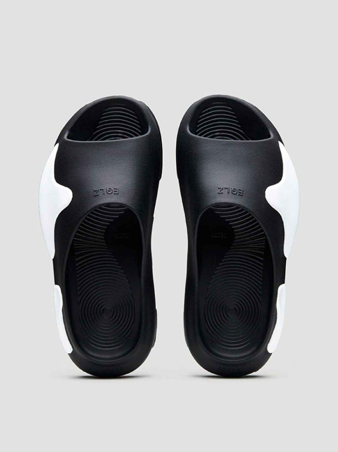 Rear inner view of black and white asymmetric colorblock cloud cushion slide sandals with textured molded footbeds