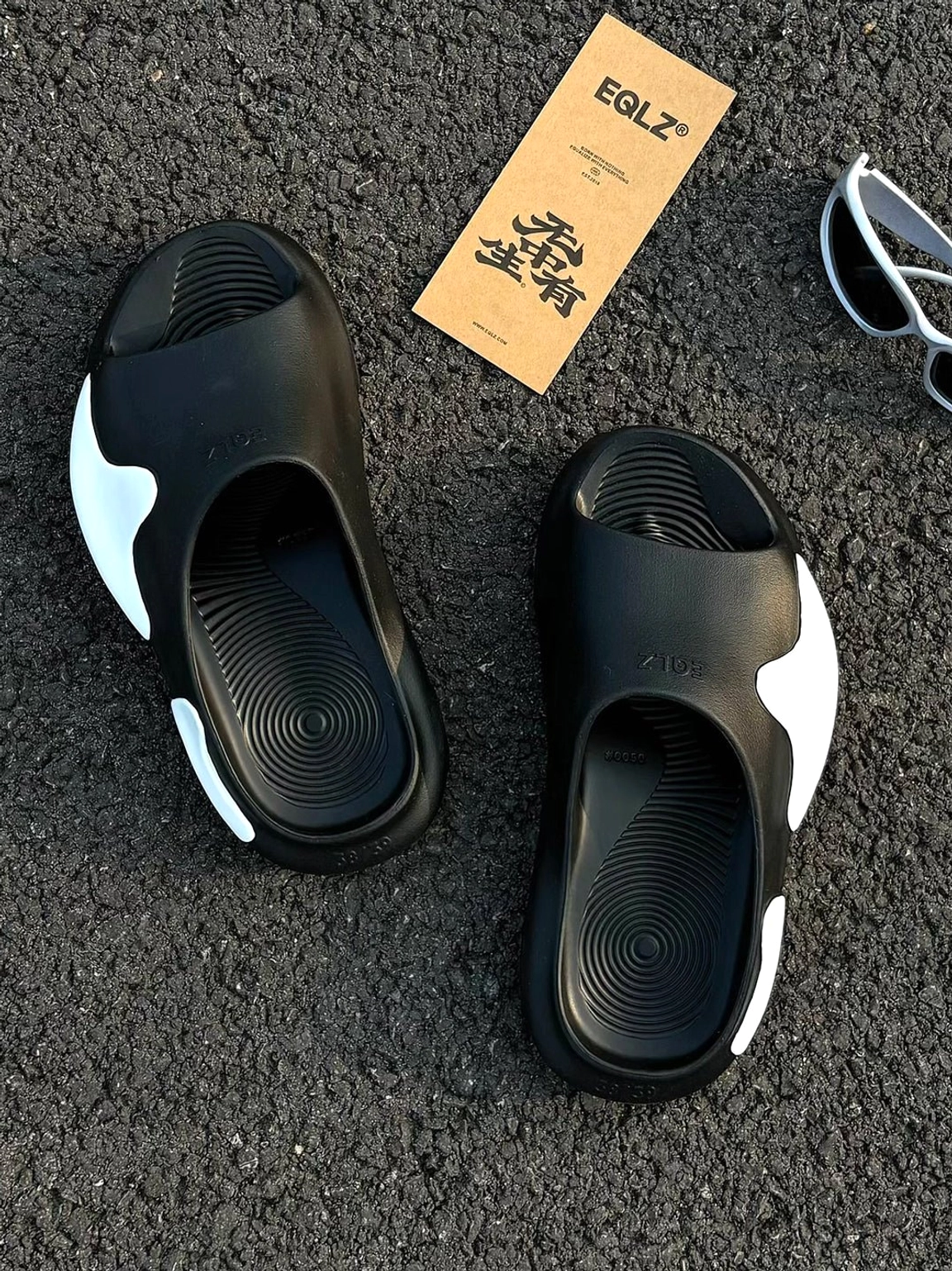 Black and white colorblock cloud cushion slide sandals flat lay showing wave textured insoles and sculpted shape