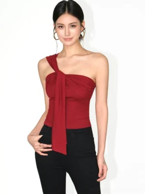 Bright retro red asymmetric one-shoulder crop top with twisted shoulder knot and slim fitted silhouette on a female model