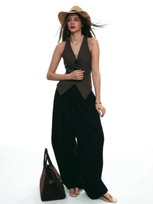 Black asymmetric draped wrap wide-leg streetwear pants with dark fitted vest full body studio outfit