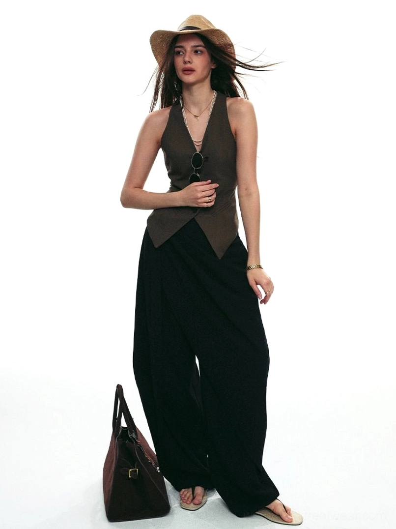 Black asymmetric draped wrap wide-leg streetwear pants with dark fitted vest full body studio outfit