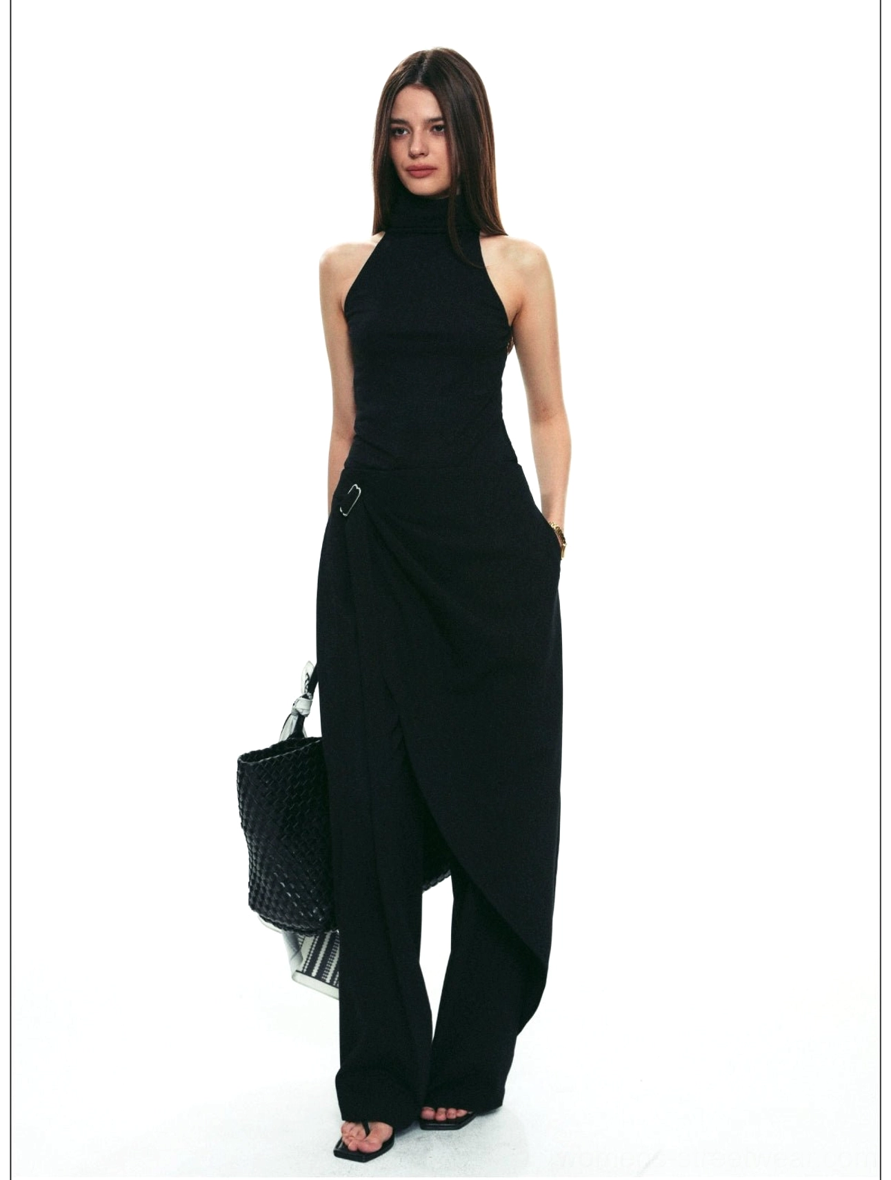 Black asymmetric wrap wide-leg streetwear pants paired with a halter neck top and woven tote bag