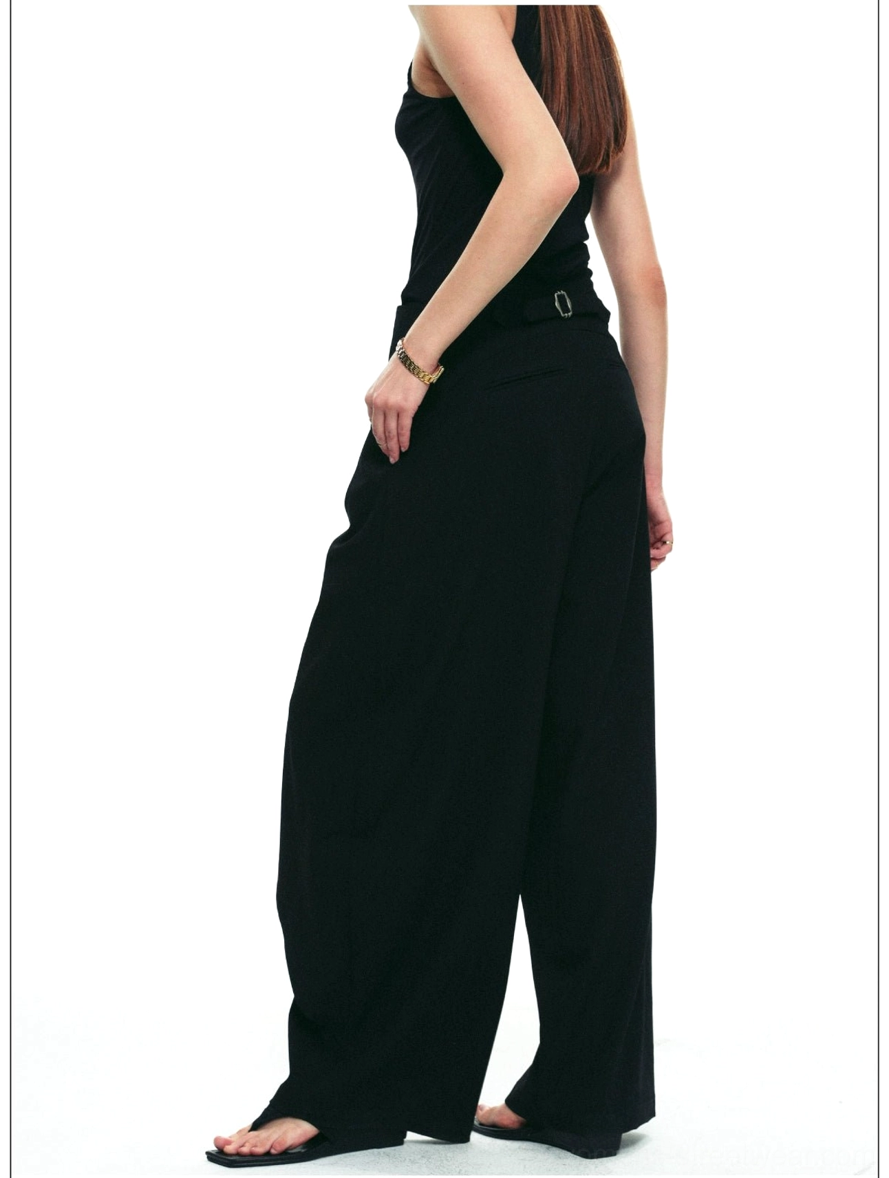 Side view of black asymmetric draped wrap wide-leg pants showing the long flowing leg shape