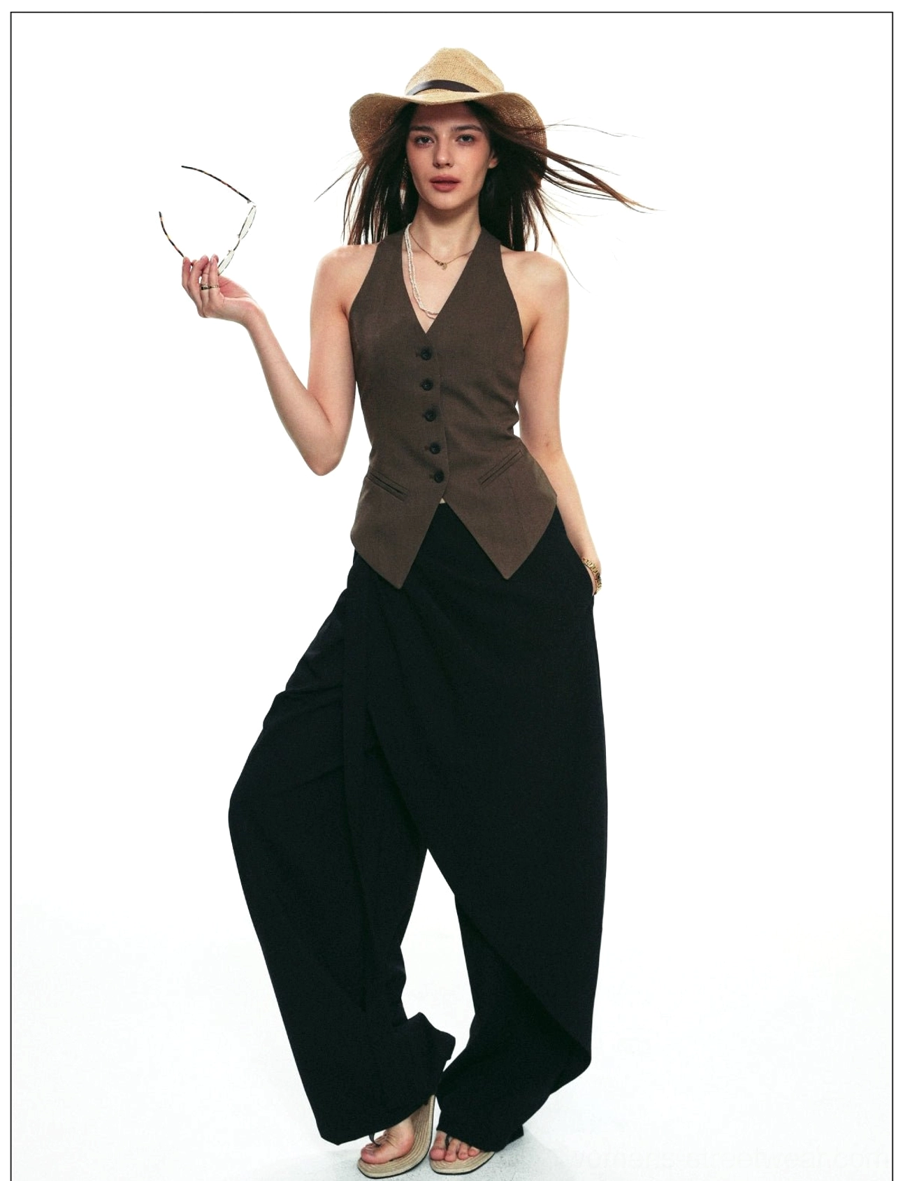 Three-quarter view of black asymmetric draped wrap wide-leg pants with layered front panel