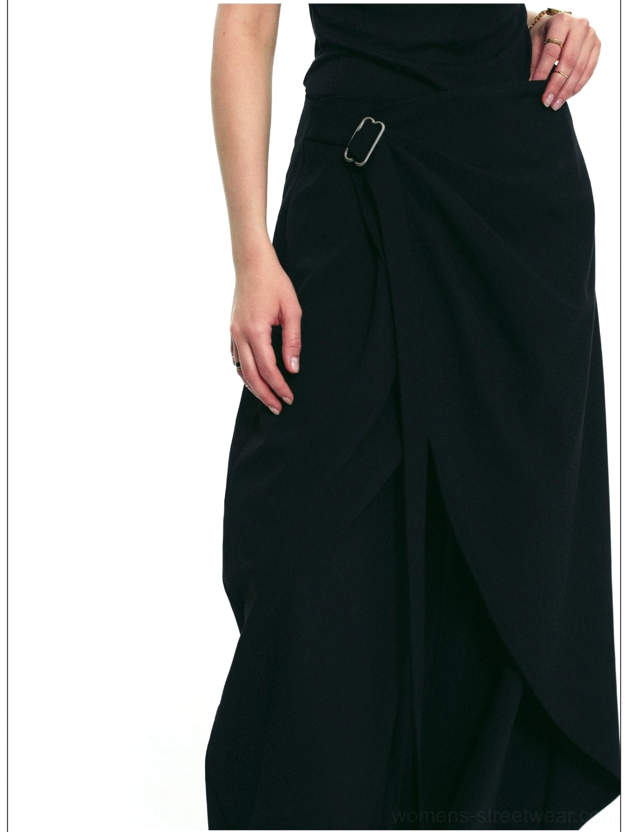 Close-up of black draped wrap wide-leg pants featuring an overlapping front panel and waist buckle detail